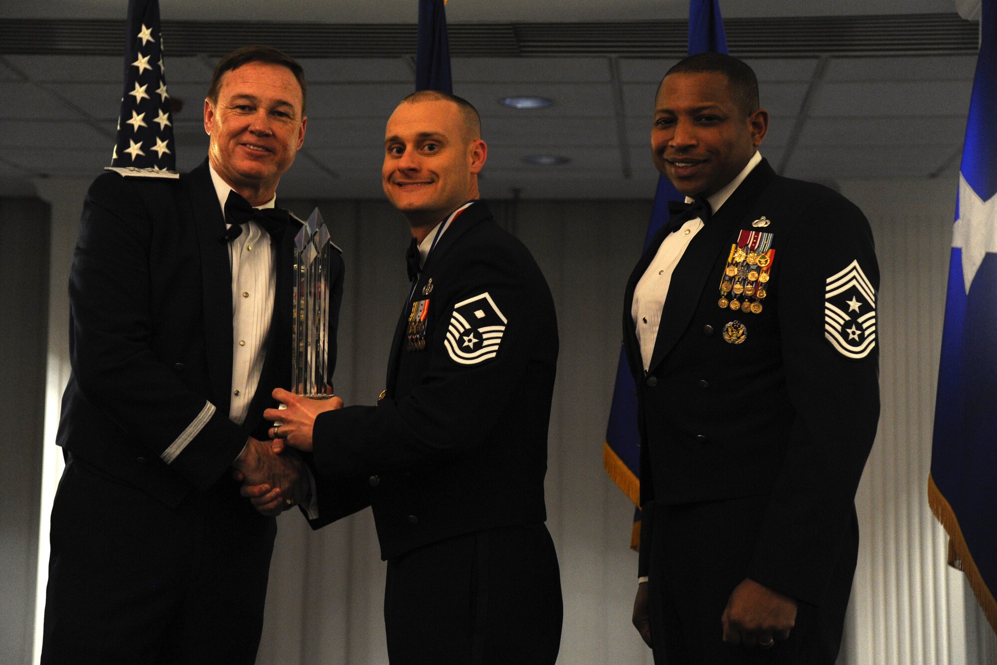 Master Sgt. Eric Villafana, 11th Wing, accepts the 2014 Air Force District of Washington Annual Awards First Sergeant of the Year trophy from AFDW Commander Maj. Gen. Darryl Burke and AFDW Command Chief Master Sgt. Farrell Thomas during the awards ceremony at Joint Base Anacostia-Bolling, D.C., March 20, 2015. (U.S. Air Force photo/Master Sgt. Tammie Moore)