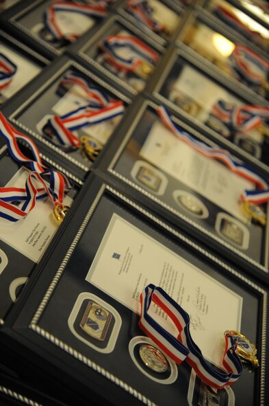 Medallions and recognition letters for the 2014 Air Force District of Washington Annual Awards nominees sit on display at the start of the awards ceremony at Joint Base Anacostia-Bolling, D.C., March 20, 2015. (U.S. Air Force photo/Master Sgt. Tammie Moore)