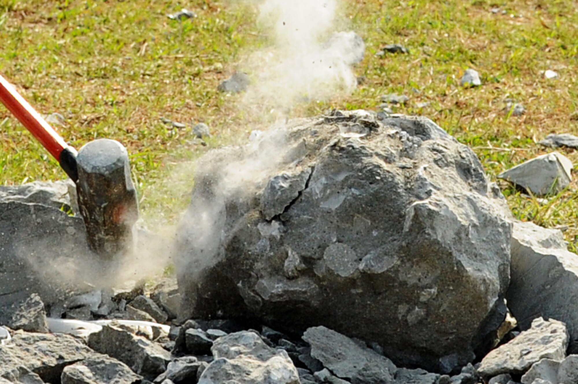 A Marine smashes a cement block during a competition on Camp Hansen, Japan, March 20, 2015. Teams of two broke apart the blocks to find a 4-inch long piece of rebar hidden inside as fast as possible to earn points for their units overall score. After totaling all of the points the winning unit was Marine Wing Support Squadron 172. (U.S. Air Force photo by Airman 1st Class Stephen G. Eigel)