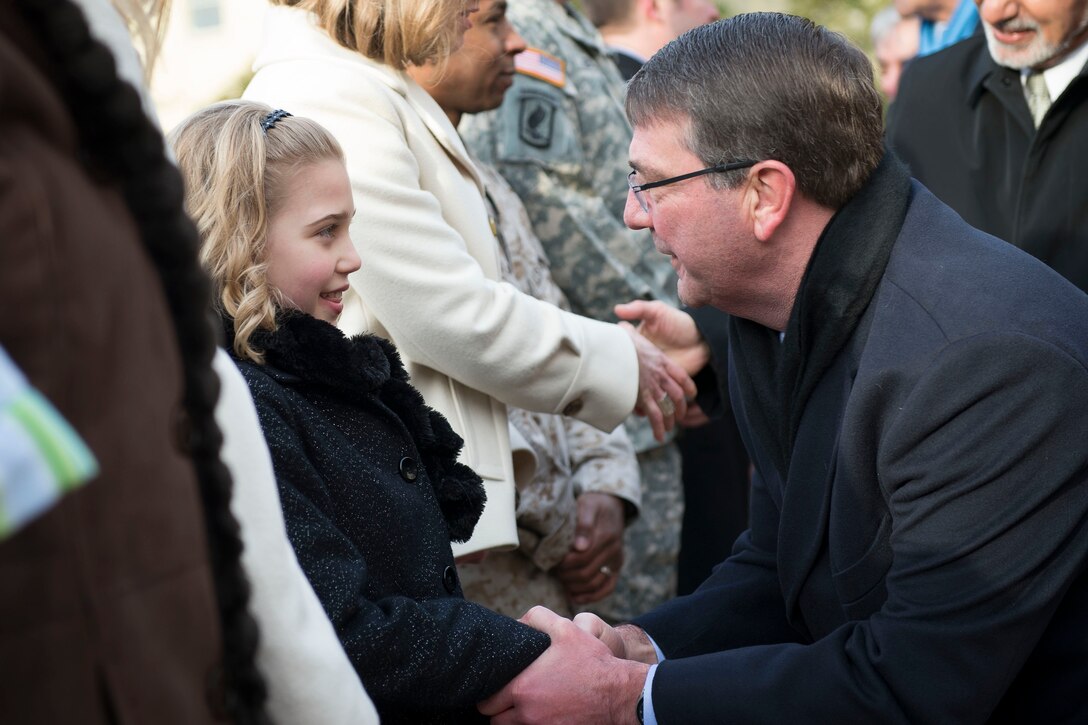 U.S. Defense Secretary Ash Carter shakes hands with Reese Larson, daughter of Navy Lt. Cmdr. Lonn Larson who is serving in Afghanistan, during a meeting with U.S. Defense Secretary Ash Carter at the Pentagon, March 23, 2015.