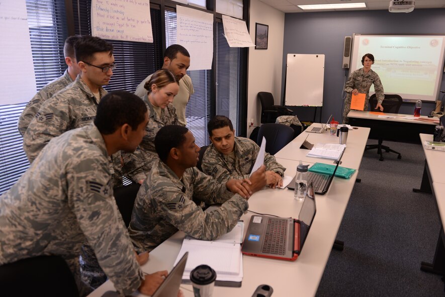 Tech. Sgt. Jamie Kienholz, non-commissioned officer in charge at Joint Base San Antonio Airman Leadership School, watches Airmen from ALS Class 15-3 work through an Introduction to Negotiation scenario at Joint Base San Antonio-Lackland, Texas, March 19, 2015. Kienholz has served as NCOIC for the past year and says the change to the developmental special duty process has brought sharp and motivated NCOs to the schoolhouse. (U.S. Air Force photo by Tech. Sgt. Joshua Strang)