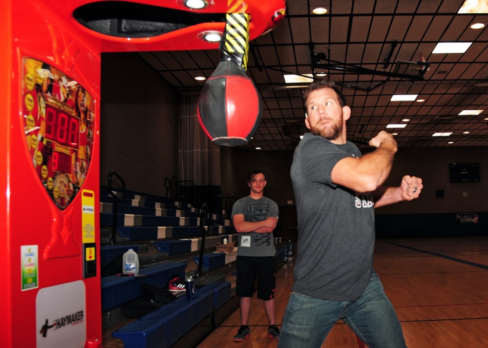 Ryan “Darth” Bader, Ultimate Fighting Champion fighter, takes a swing at the Haymaker vending machine to measure his punching power Mar 21 during the UFC Fitness Tour 2015 at the Bryant Fitness Center, Luke Air Force Base, Ariz. (U.S. Air Force photo taken by Tech. Sgt. Louis Vega Jr.)
