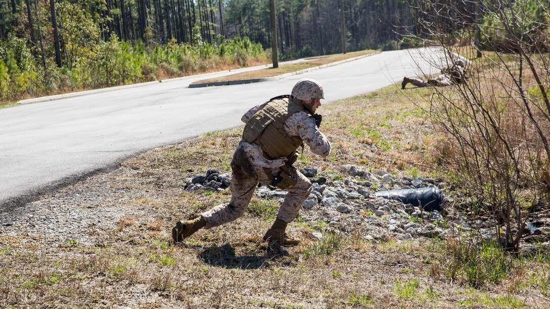 Sailors with 2nd Dental Battalion take cover while coming under simulated small-arms fire during a counter improvised explosive device course in Holly Ridge, N.C., March 20, 2015. During the scenario, the sailors were attacked by simulated small-arms fire and had simulated IEDs detonate near them. 