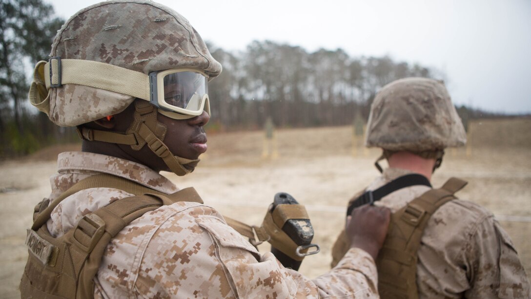 Corporal Direll McKnight, a bulk fuel specialist with Bulk Fuel Company, 8th Engineer Support Battalion, 2nd Marine Logistics Group, holds onto the Marine in front of him during the movement portion of the table-three shooting qualification aboard Marine Corps Base Camp Lejeune, N.C., March 19, 2015. The table is a yearly requirement for Marines in certain units, and it assists in teaching them how to fire on targets while maneuvering. 