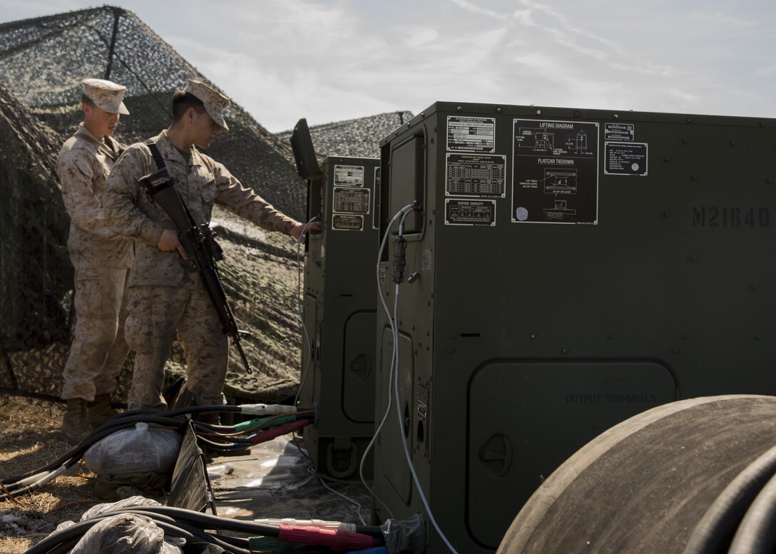 Lance Cpl. Edgar Hernandez, right, an engineer equipment mechanic with 8th Communication Battalion, II Marine Expeditionary Force, inspects a generator to ensure it is functioning properly during the unit’s field exercise aboard Camp Lejeune, N.C., March 11, 2015. This field exercise allows Marines to perform their duties in a tactical environment. (U.S. Marine Corps photo by Cpl. Justin T. Updegraff/Released)