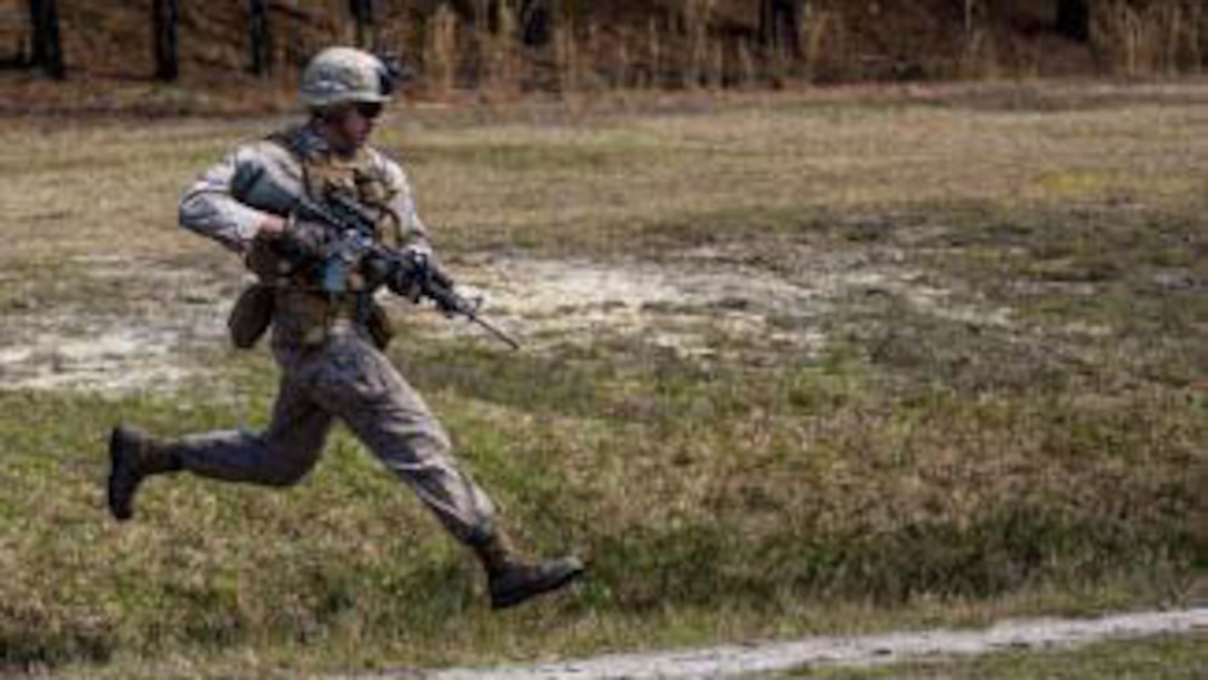 A Marine with Charlie Company, 1st Battalion, 6th Marine Regiment advances across a field during a live-fire, fire-team attack range exercise aboard Camp Lejeune, N.C., March 18, 2015. One fire-team at a time conducted the attack, advancing across a field while providing suppressive fire and utilizing various munitions. 