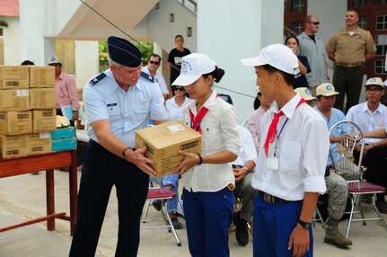 In this file photo, an Air Force Officer presents donated schools supplies and toys to children in Quang Tri Province, Vietnam. The donations were presented as part of Operation Pacific Angel to provide humanitarian assistance in cooperation with local authorities to area residents.