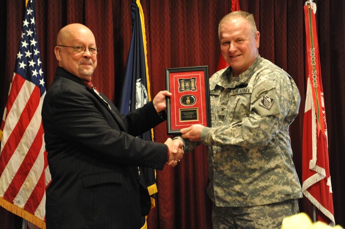 Charles Twing is presented a memento by Col. Robert Ruch, Huntsville Center commander, during Twing's retirement ceremony March 20. Twing served more than 24 years with Huntsville Center and was a pioneer in the Center's ordnance programs.