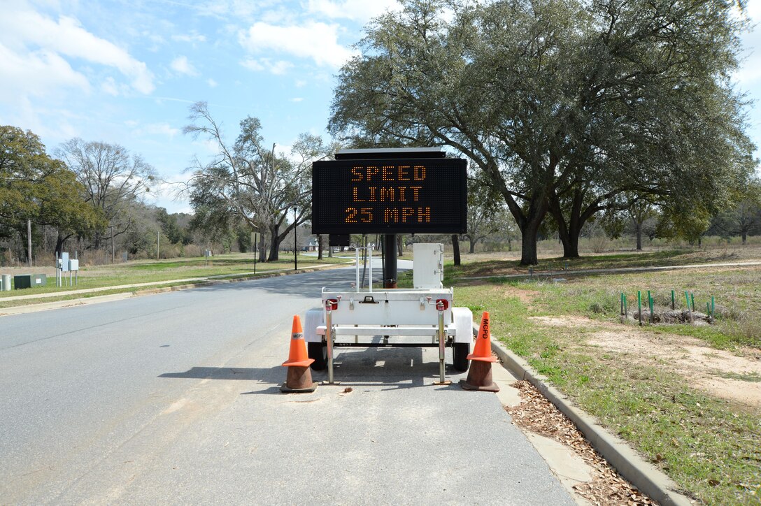 Flashing signage near base housing serves as a reminder of the speed limit for drivers.