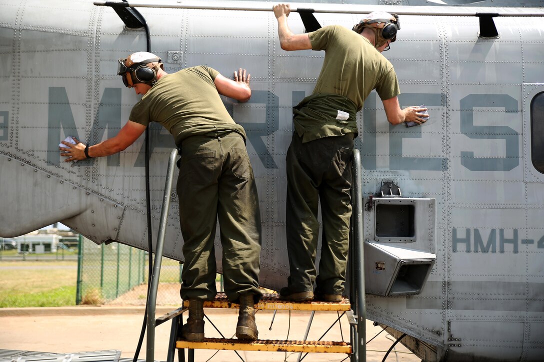 Lance Cpl. Steven Atwood, left, and Lance Cpl. Keegan Smith, both aviation mechanics with Marine Heavy Helicopter Squadron 463, scrub a CH-53E Super Stallion helicopter March 17, 2015, in preparation for an inspection aboard Marine Corps Base Hawaii. The unit prepared five CH-53Es to send to Marine Rotational Force-Darwin, Australia later this year. It takes 1,500 man-hours per aircraft to make the aircraft inspection-ready for deployment to Australia.