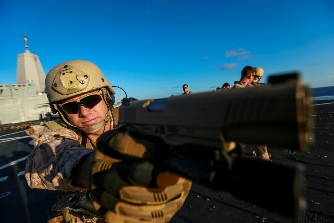 U.S. Marine Gunnery Sgt. Mickey Eaton sights in with his M1911 .45 caliber pistol at a target during Composite Training Unit Exercise (COMPTUEX) aboard the USS Anchorage (LPD 23) off the coast of San Diego March 23, 2015. Eaton is the assistant operations chief of the 15th Marine Expeditionary Unit's Maritime Raid Force. The 15th MEU's MRF Marines constantly sharpen their skills with different weapon systems to maintain a high level of readiness. (U.S. Marine Corps photo by Sgt. Jamean Berry/Released)