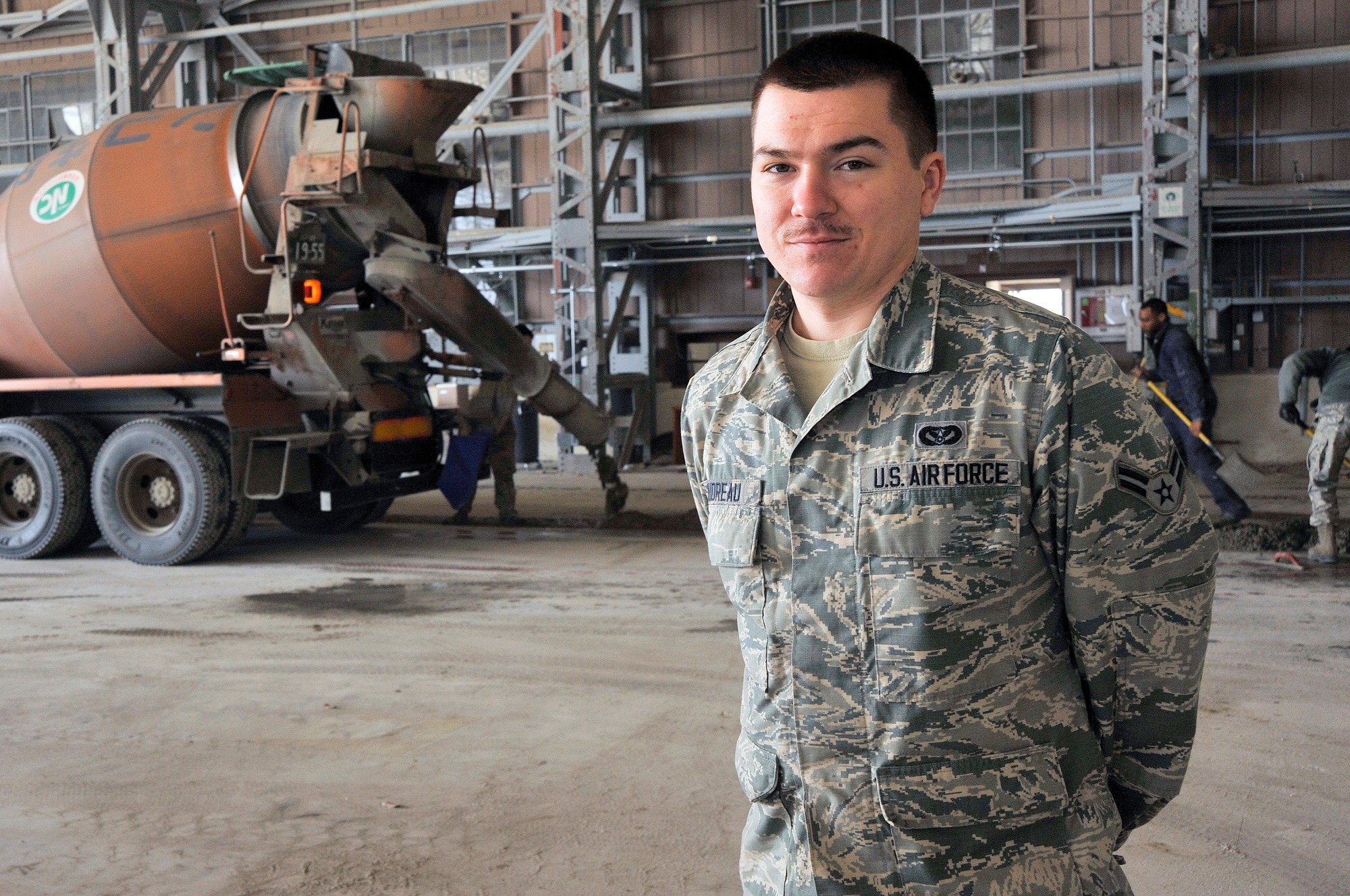 U.S. Air Force Airman 1st Class Jim Boudreau, 35th Civil Engineer Squadron structural apprentice, poses in front of paving equipment used at Misawa Air Base, Japan, Mar. 19, 2015. Boudreau and the team of structural maintainers he is part of ensure upkeep of base facilities and infrastructure across Misawa AB. (U.S. Air Force photo by Senior Airman Jose L. Hernandez-Domitilo/Released)