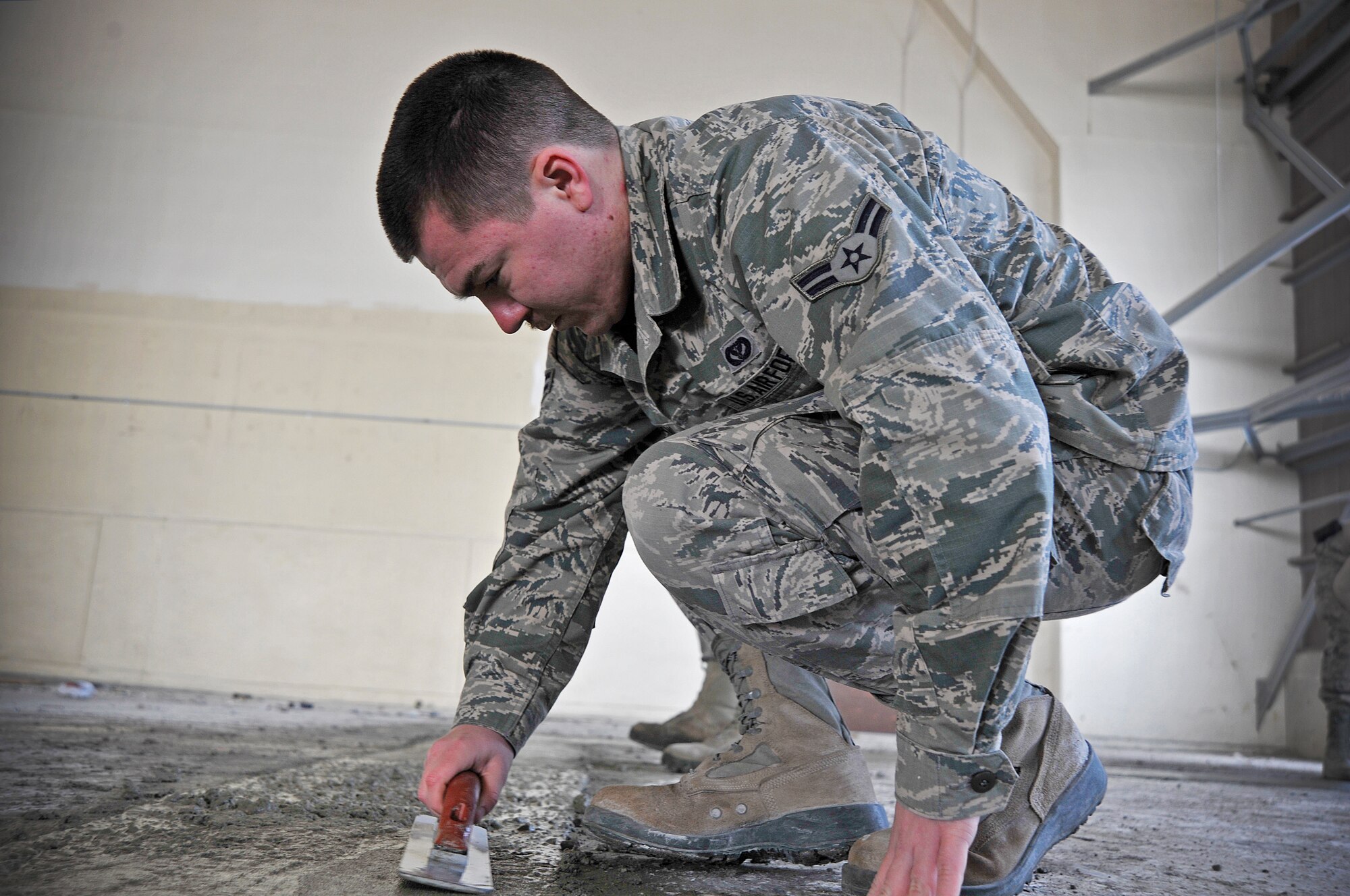U.S. Air Force Airman 1st Class Jim Boudreau, 35th Civil Engineer Squadron structural apprentice, smoothens out concrete filling at Misawa Air Base, Japan, March 19, 2015. Boudreau and his team of structural maintainers were repaving portions of a dock by the flight line as part of a renovation project. (U.S. Air Force photo by Senior Airman Jose L. Hernandez-Domitilo/Released)