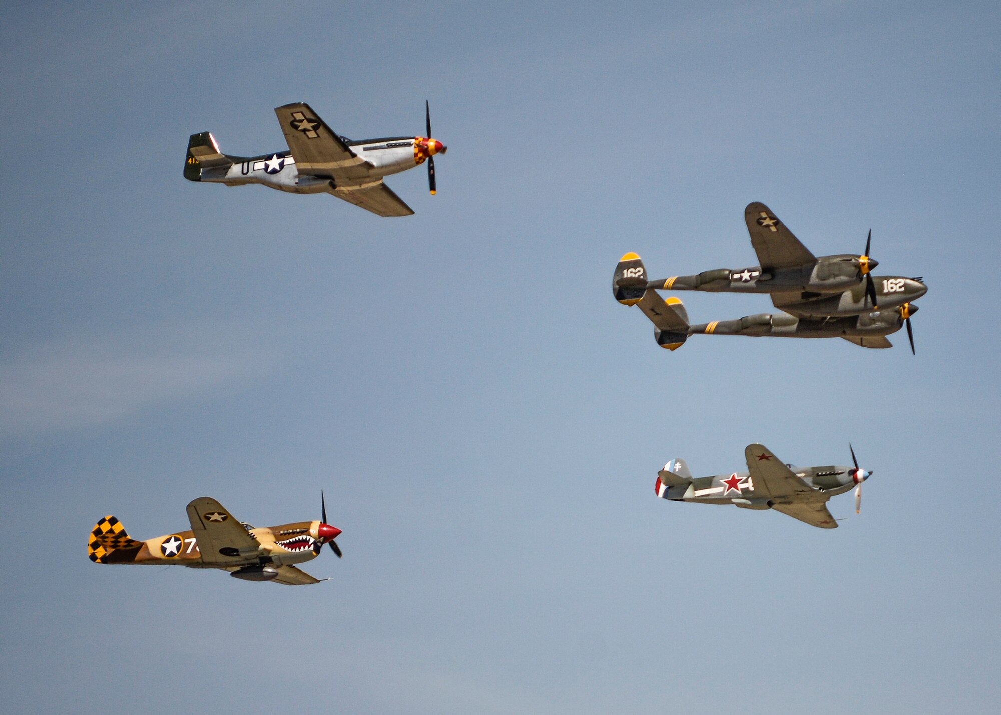 The Planes of Fame Air Museum from Chino, California, brought in a collection of warbirds for formation flights and static displays to the 2015 L.A. County Air Show. Flying in formation were the P-38 Lightning (front), P-51 Mustang (top), P-40 Warhawk (bottom left) and a Yak-3. (U.S. Air Force photo by Rebecca Amber)