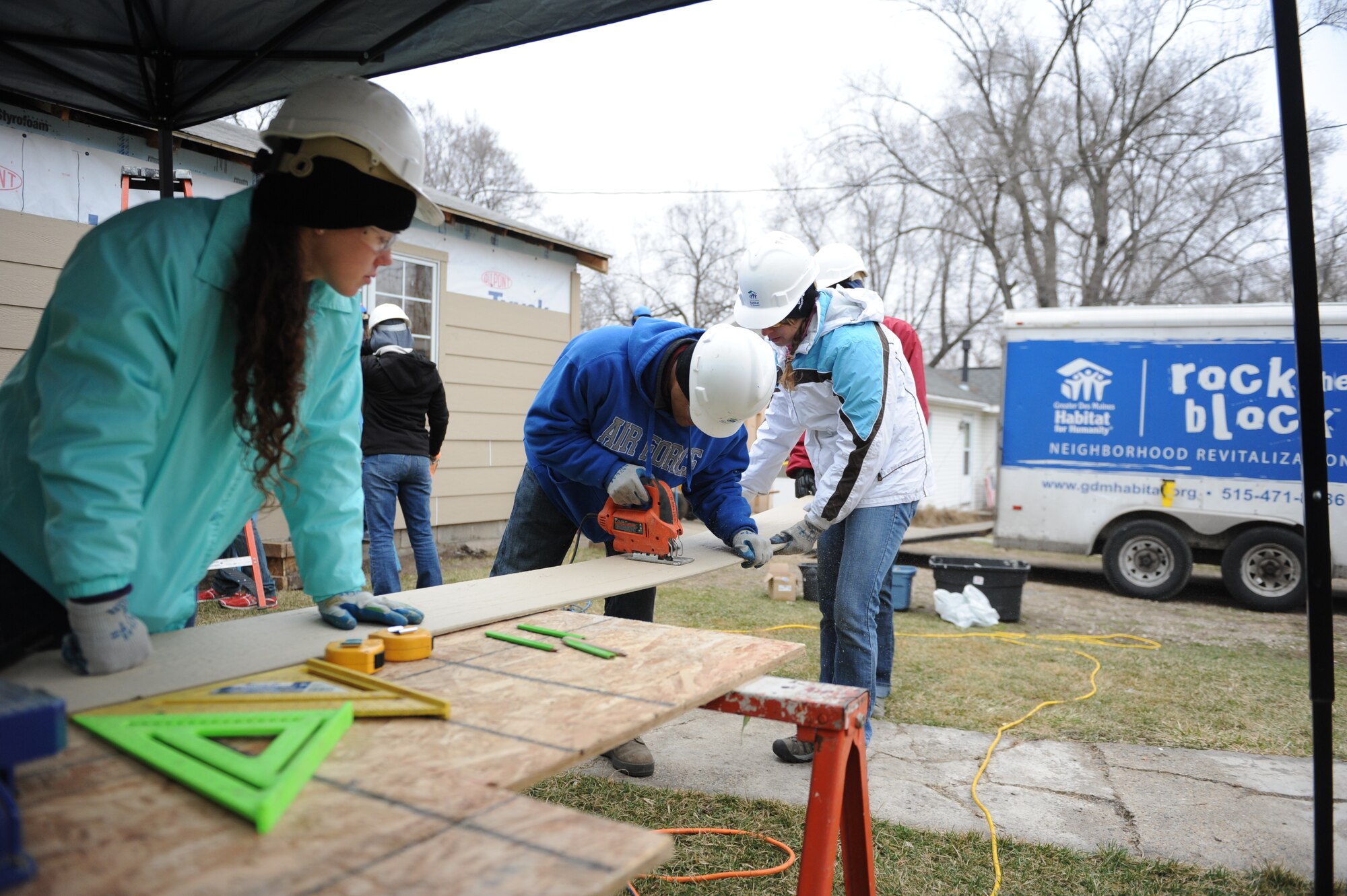 Cadet 4th Class Gabriel Houston, center, measures before a cut. Houston is one of 60 Air Force Academy cadets taking part in the Academy’s Alternative Spring Break program March 23-27, 2015, helping build and upgrade homes in Des Moines, Iowa, Houston, El Paso, Texas, Oklahoma City and Montrose, Colo. (Air force photo/John Van Winkle)