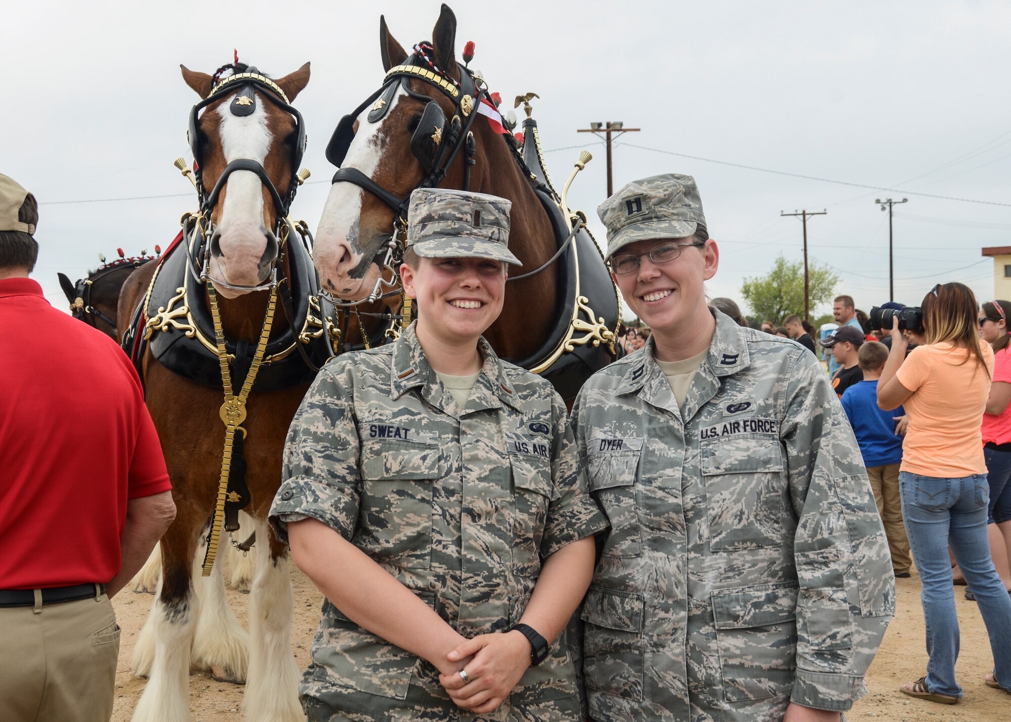 2nd Lt. Amanda Sweat and Capt. Regina Dyer, Air Force Operational Test and Evaluation Center Detachment 5, pose for a photo with the famous Budweiser Clydesdales during the show team's visit to Arnold Park March 18. (U.S. Air Force photo by Rebecca Amber)