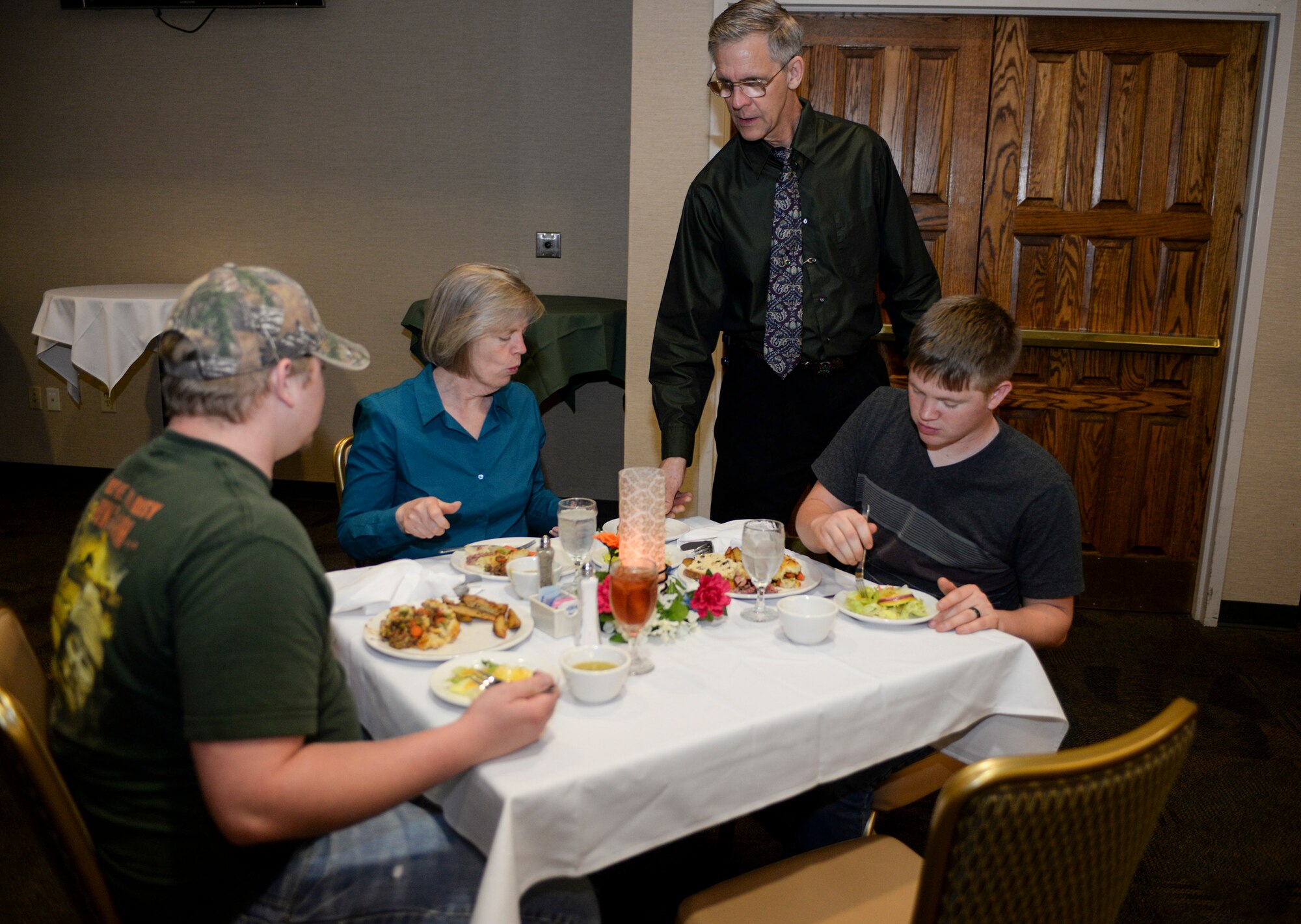 Mick Widner, Moody Field Club food service worker, serves food to Naomi Hendricks, 23d Civil Engineer Squadron housing manager, and her sons Justin and Matthew Hendricks, during the Luck of the Irish Lunch Buffet at March 18, 2015 at Moody Air Force Base, Ga. The meal options were Shepherd’s Pie, corned beef with cabbage, mashed potatoes, salad, pea and ham soup, fried chips and chocolate pudding. (U.S. Air Force photo by Senior Airman Sandra Marrero/Released)

