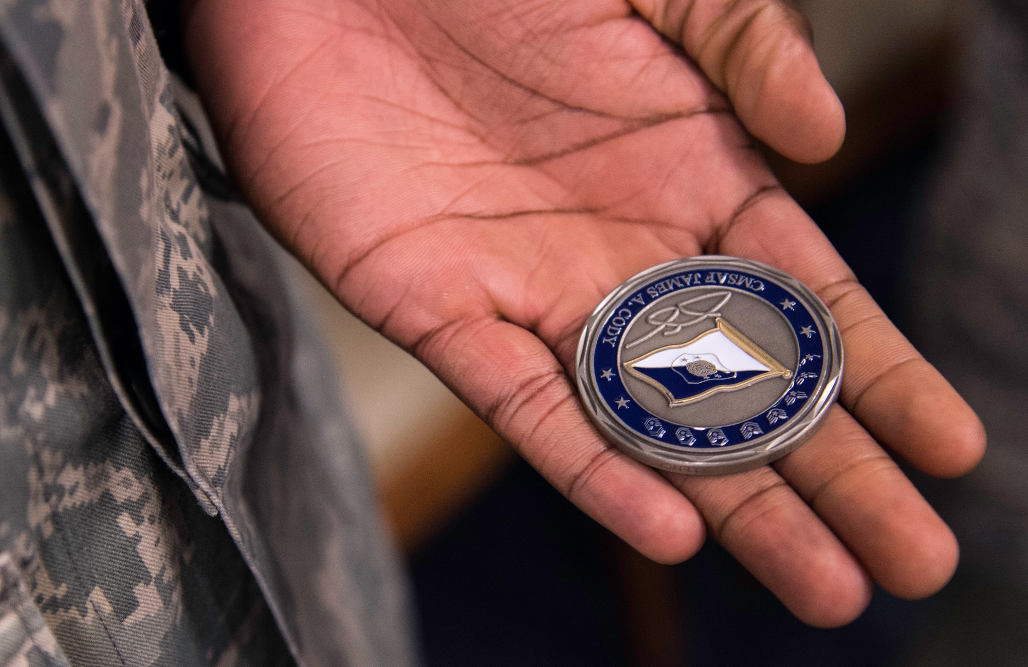 Senior Airman Tyrell Patton, 11th Wing paralegal, holds his newly received coin from Chief Master Sergeant of the Air Force James Cody at Joint Base Andrews, Md., March 23, 2015. Cody coined two Airmen for their career excellence during his visit. (U.S. Air Force photo/Airman 1st Class Philip Bryant)
