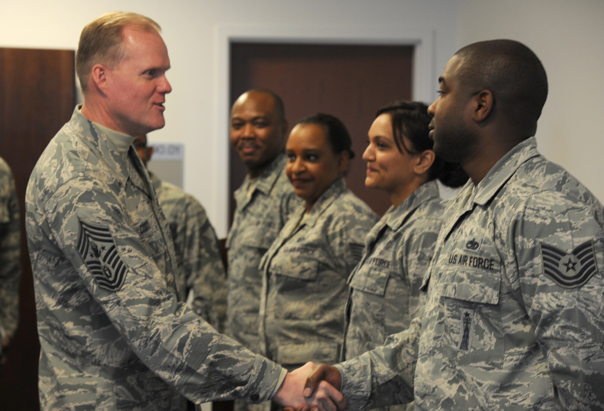 Chief Master Sgt. of the Air Force James Cody introduces himself to Staff Sgt. Thomas White during his visit with Air Force District of Washington Airmen at Joint Base Andrews, Md., March 23, 2015. White is the AFDW unit training manager. (U.S. Air Force photo/Master Sgt. Tammie Moore)
