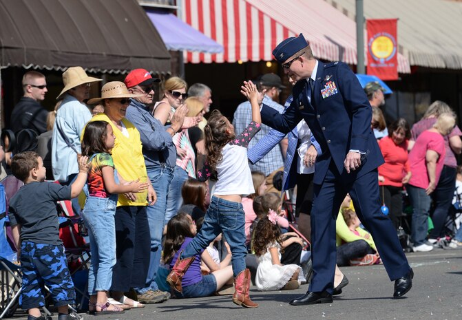 Col. Douglas Lee, 9th Reconnaissance Wing commander, gives a high-five during the Bok Kai Festival in Marysville, Calif., Mar. 21, 2015. The festival has been held in Marysville for 135 years. (U.S. Air Force photo by Staff Sgt. Robert M. Trujillo/Released)