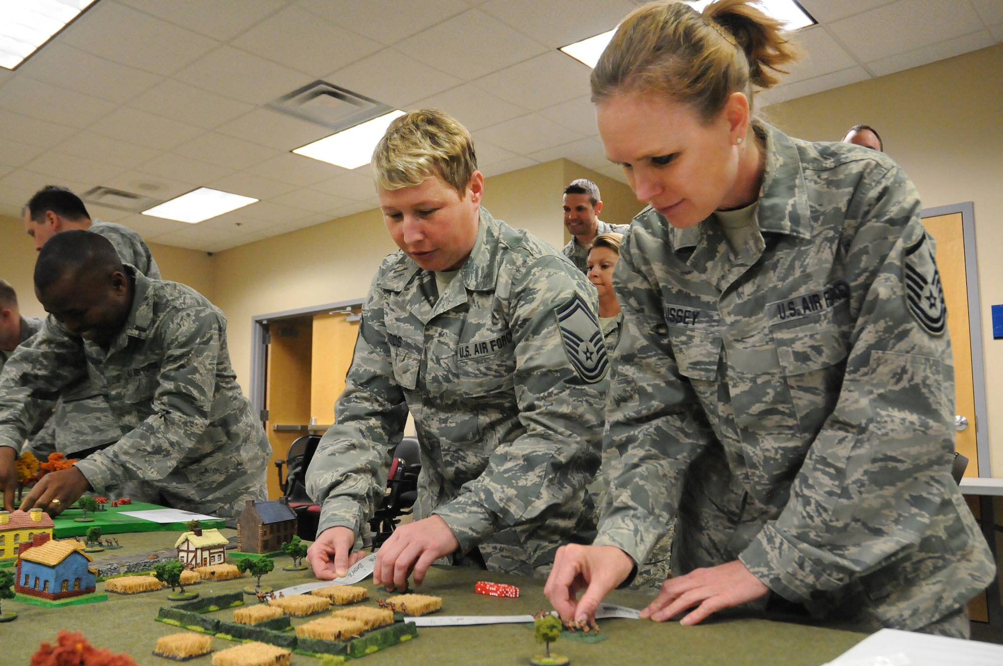 Senior Master Sgt. Shannon Woods and Master Sgt. Aaronnett Bussey, both from the 138th Logistics Readiness Squadron, plot their next move during a table top exercise with during a leadership meeting held Mar. 18, 2015, at the Tulsa Air National Guard Base, Okla.   Since August 2014, every Wednesday following their monthly unit training assembly, leaders from around the 138th Fighter Wing have shared various leadership perspectives, and encouraged open and honest communication while learning from each other at wing leadership meetings .  (U.S. National Guard photo by Senior Master Sgt.  Preston L. Chasteen/Released)