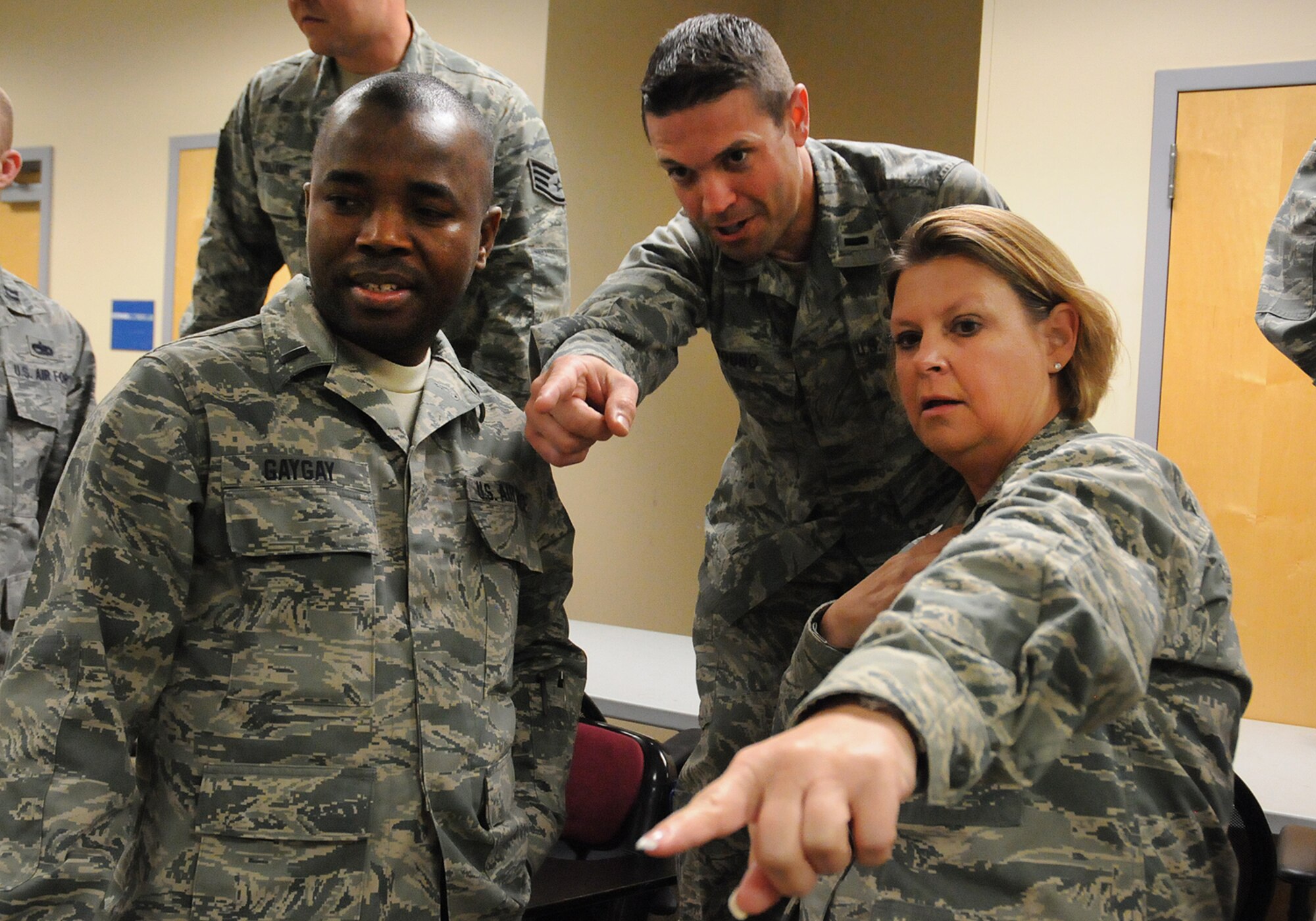Lt. Col. Robin Cavanaugh (right), 138th Logistics Readiness (LRS) commander,  discusses strategy with team members,  1Lt. Joshua Young (center), 138th LRS, and 1Lt. Robert Gaygay (left), 138th Medical Group,  during a leadership meeting held Mar. 18, 2015, at the Tulsa Air National Guard Base, Okla.   Since August 2014, every Wednesday following their monthly unit training assembly, leaders from around the 138th Fighter Wing have shared various leadership perspectives, and encouraged open and honest communication while learning from each other at wing leadership meetings .  (U.S. National Guard photo by Senior Master Sgt.  Preston L. Chasteen/Released)