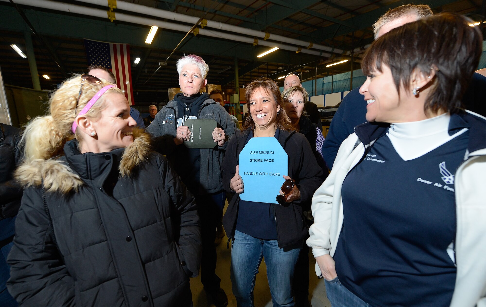 Lori Ewald, 436th Force Support Squadron honorary commander, holds up a ceramic body-armor plate while others in her group look on during a tour of the 436th Security Forces Squadron warehouse and training facility March 18, 2015, on Dover Air Force Base, Del. The honorary commanders got to see some of the specialized equipment used by the SFS as they learned about their mission. (U.S. Air Force photo/Greg L. Davis)