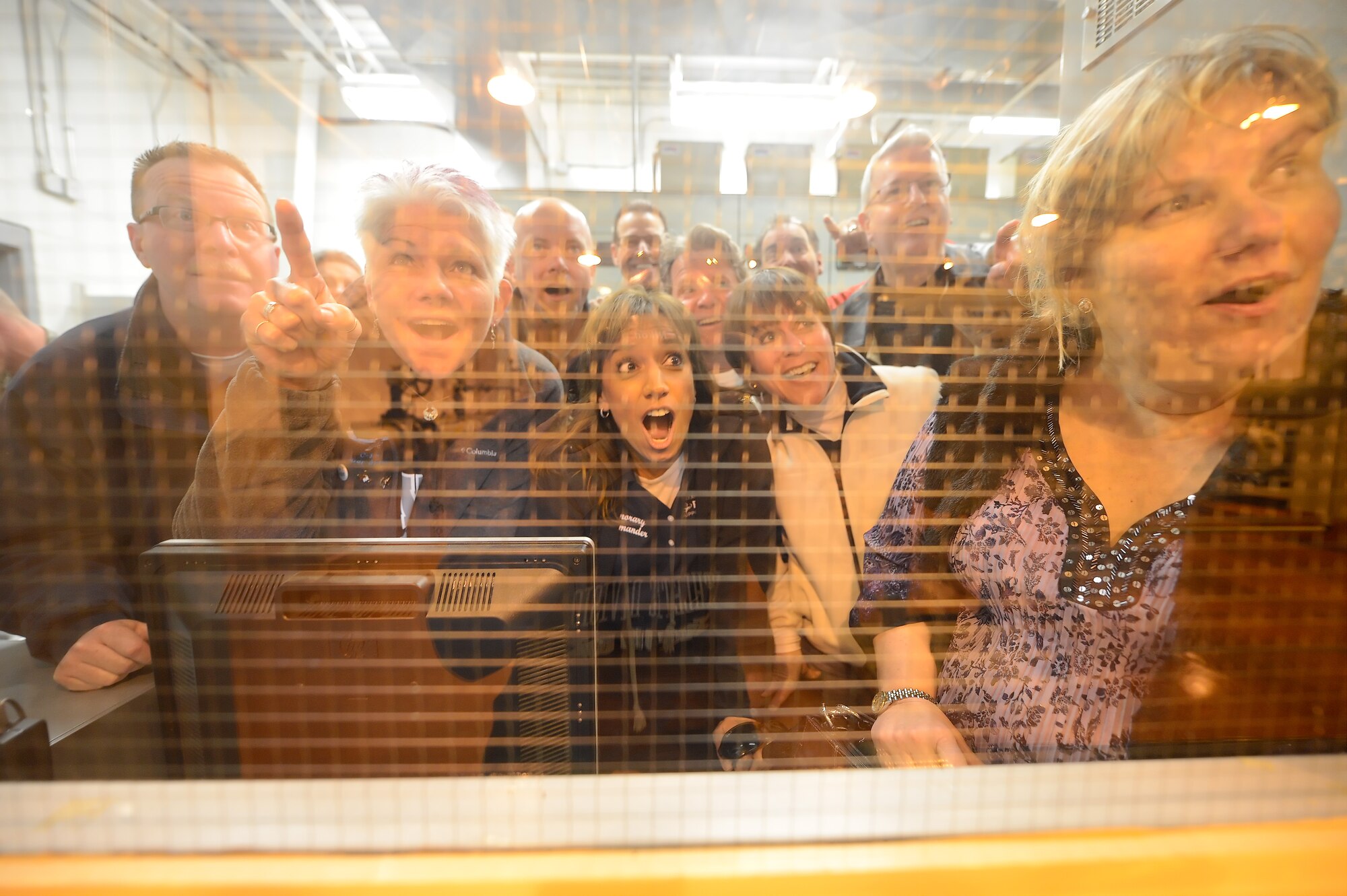 A group of honorary commanders look out with mock amazement from the control room of the petroleum pump house operated by the 436th Logistics Readiness Squadron during a tour of the facility March 18, 2015, on Dover Air Force Base, Del. The facility moves fuel from large storage tanks to underground delivery stations on the flight line and the area being viewed is filled with a complicated maze of piping, pumps and specialized equipment. (U.S. Air Force photo/Greg L. Davis)