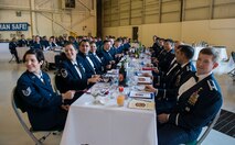 Airmen bang their spoons during the 2nd Annual Dining-In March 20, 2015, at Moody Air Force Base, Ga. Banging spoons, instead of clapping was one of the rules of the mess and violators of the mess were required to drink from the traditional grog bowl. (U.S. Air Force photo by Airman 1st Class Ceaira Tinsley/Released)