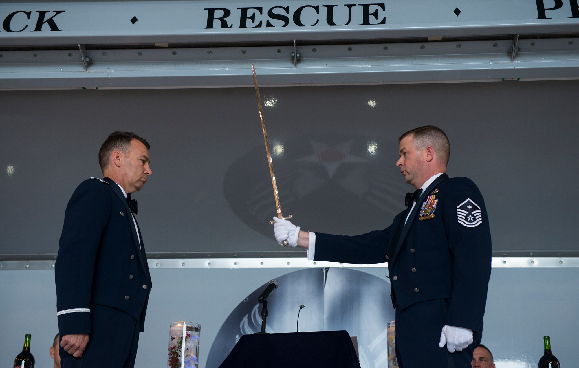 U.S. Air Force Master Sgt. Rusty Sawyer, 23d Medical Group first sergeant and ceremonial sergeant at arms, right, presents a sword to Col. Chad Franks, 23d Wing commander, during the 2nd Annual Dining-In March 20, 2015, at Moody Air Force Base, Ga. The sergeant at arms acted as the demonstrator and enforcer of the rules of the mess. (U.S. Air Force photo by Airman 1st Class Ceaira Tinsley/Released)