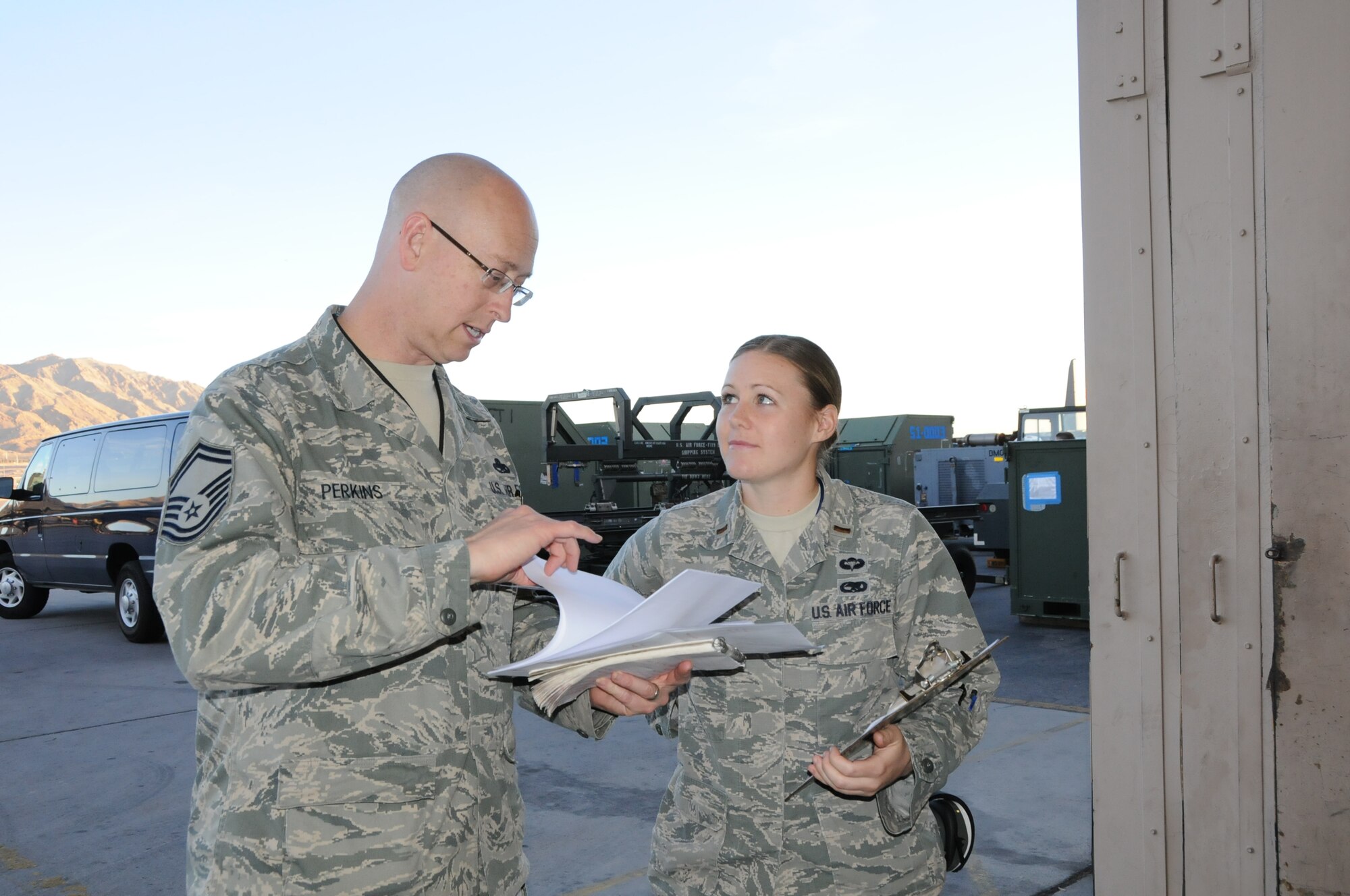 Senior Master Sgt. Al Perkins, Virginia Air National Guard, 192nd Fighter Wing, Red Flag project officer and 2nd Lieutenant Jessica Grier, assistant Officer In Charge for the 94th Aircraft Maintenance Unit, Joint Base Langley Air Force Base review shift change meeting notes during Red Flag 15-1 at Nellis Air Force Base, Nev., Feb. 3, 2015.  Total Force Integration played a major role during the Red Flag exercise which is a realistic combat training exercise where U.S. military and coalition forces push personnel and aircraft to their limits at Nellis Air Force Base, Nv. (U.S. Air National Guard photo by Master Sgt. Carlos J. Claudio/Released)