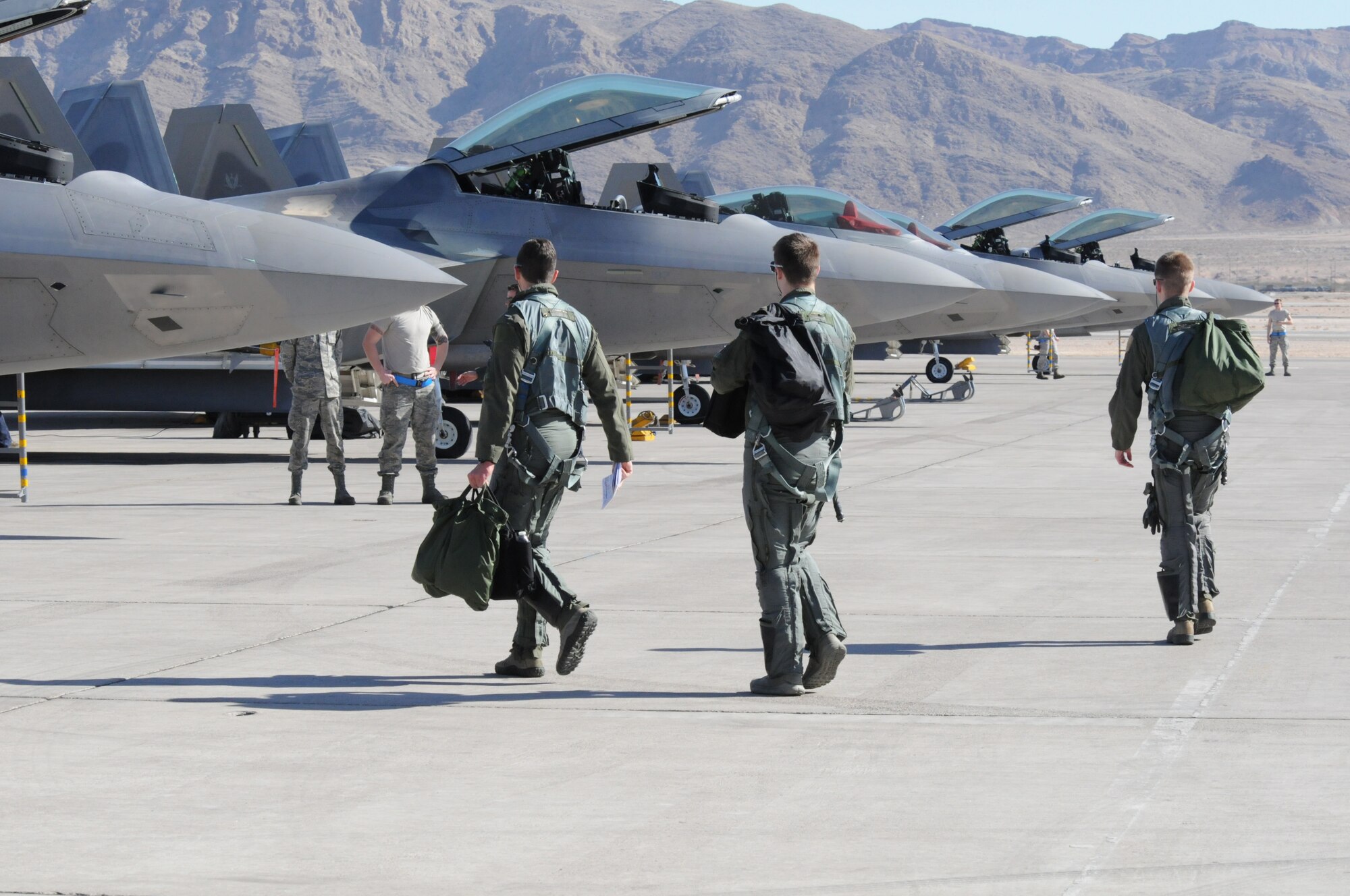 F-22A Raptor pilots from the 192nd and 1st Fighter Wing, Langley Air Force Base, Va., step to their jets during the 40th anniversary of the Red Flag combat training exercise, Red Flag 15-1 at Nellis Air Force Base, Nev., Feb. 3, 2015.  Red Flag is a realistic combat training exercise involving the air, space and cyber forces of the U.S. and its allies. It is conducted on the bombing and gunnery ranges on the Nevada Test and Training Range. (U.S. Air National Guard photo by Master Sgt. Carlos J. Claudio/Released)