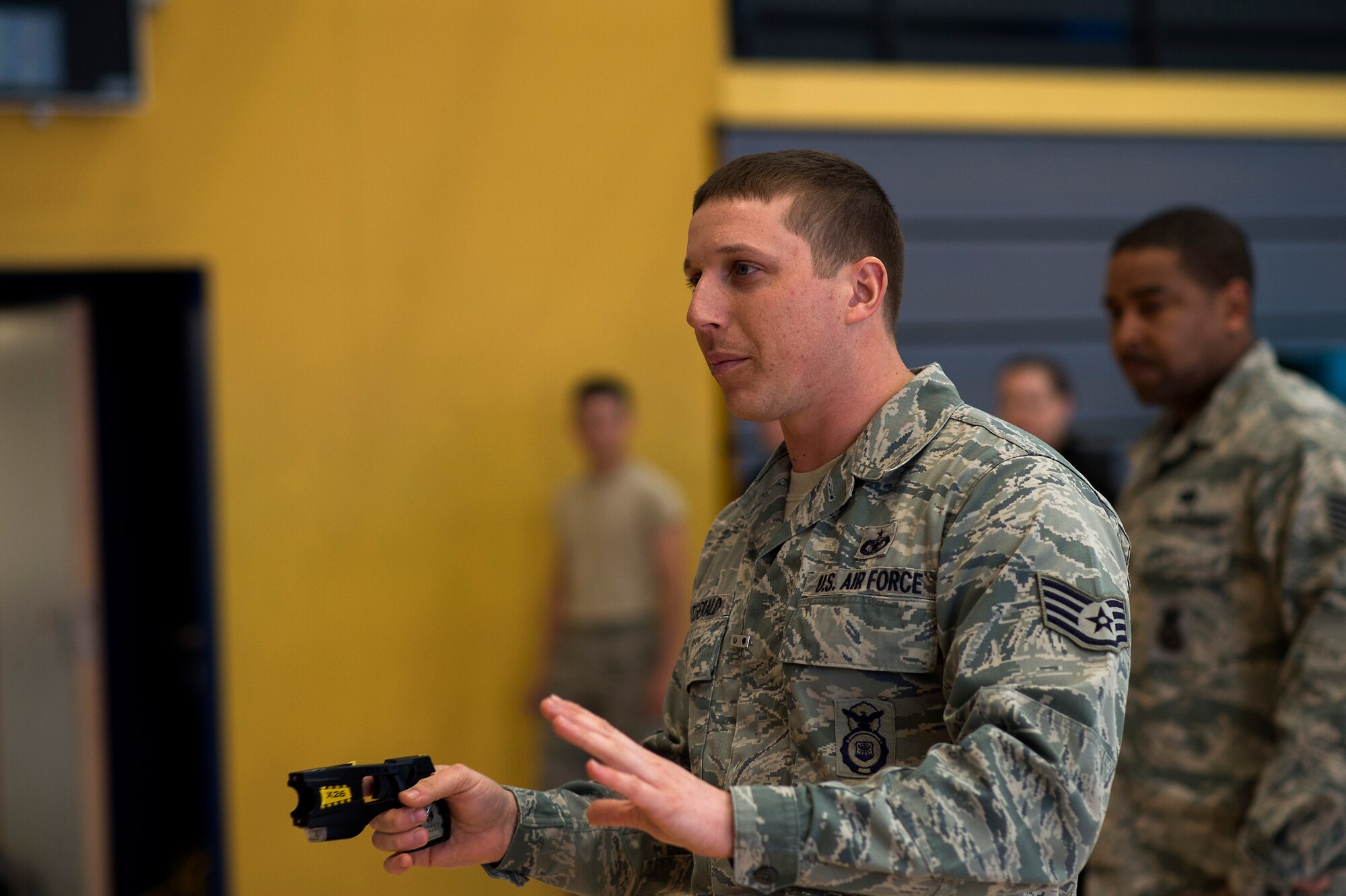 Staff Sgt. Jeffery Fitzgerald, 86th Security Forces Squadron instructor, informs people about Tasers during a self-defense seminar at Ramstein Air Force Base, Germany, March 20, 2015. Attendees of the seminar had the option to experience firsthand the effects of being immobilized by a stun gun. (U.S. Air Force photo/Senior Airman Damon Kasberg)