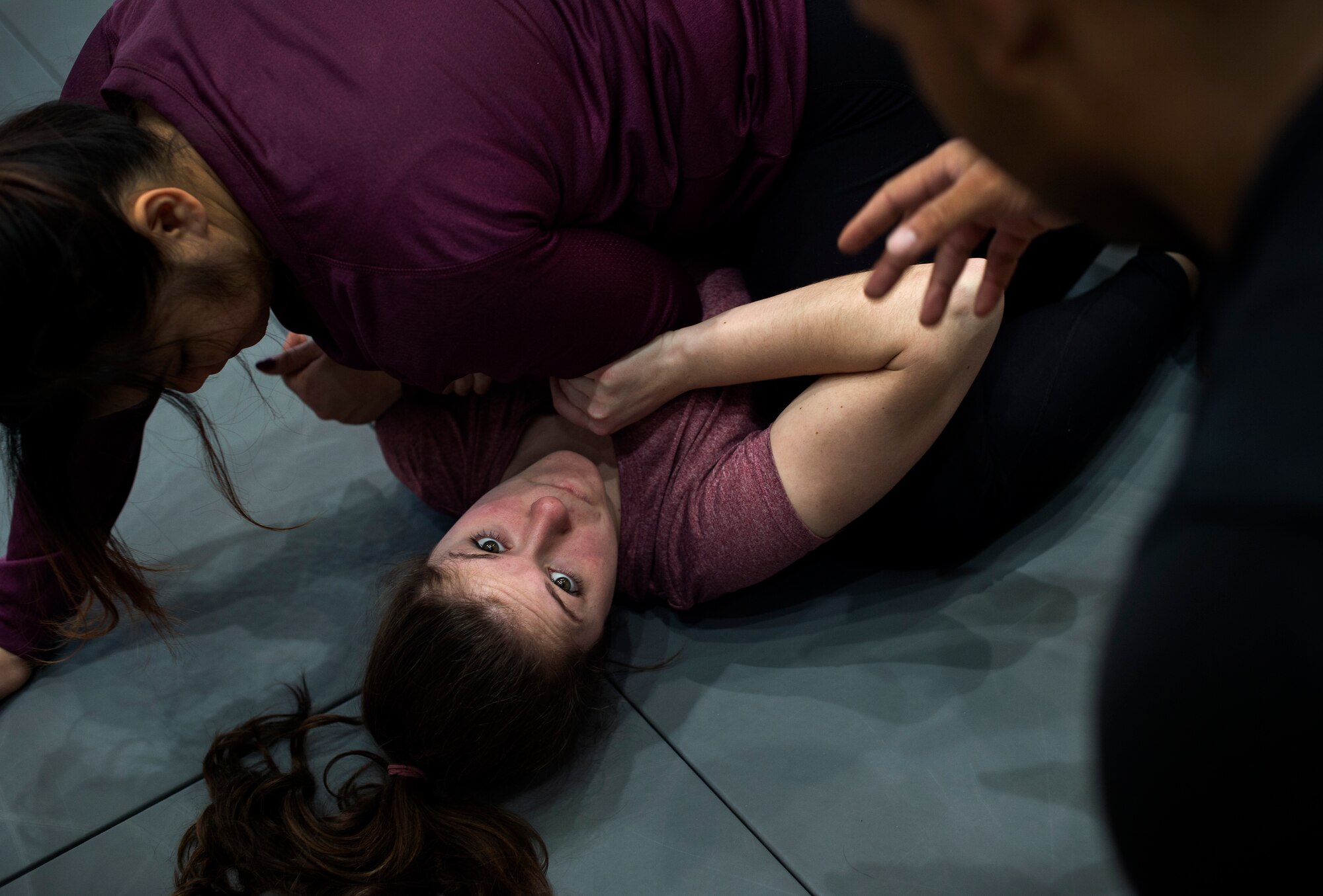 Courtney Ferry listens to a member of the 86th Security Force Squadron as he instructs her on getting out of the guard position during a self-defense seminar at Ramstein Air Force Base, Germany, March 20, 2015. The 86th SFS taught a variety of self-defense moves including punches, kicks and grapples. The seminar was not only open to military members, but spouses as well. (U.S. Air Force photo/Senior Airman Damon Kasberg)