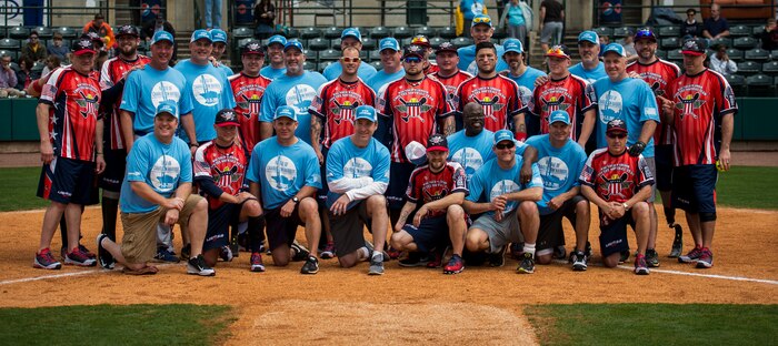 Members of the Wounded Warrior Amputee Softball Team and The Citadel 1990 College World Series baseball team gather for a group photo March 21, 2015, at Joe Riley Stadium in Charleston, S.C. The “Battle of Charleston Harbor” was a softball game between the Wounded Warrior Amputee Softball Team and The Citadel 1990 College World Series baseball team. (U.S. Air Force photo/Airman 1st Class Clayton Cupit)