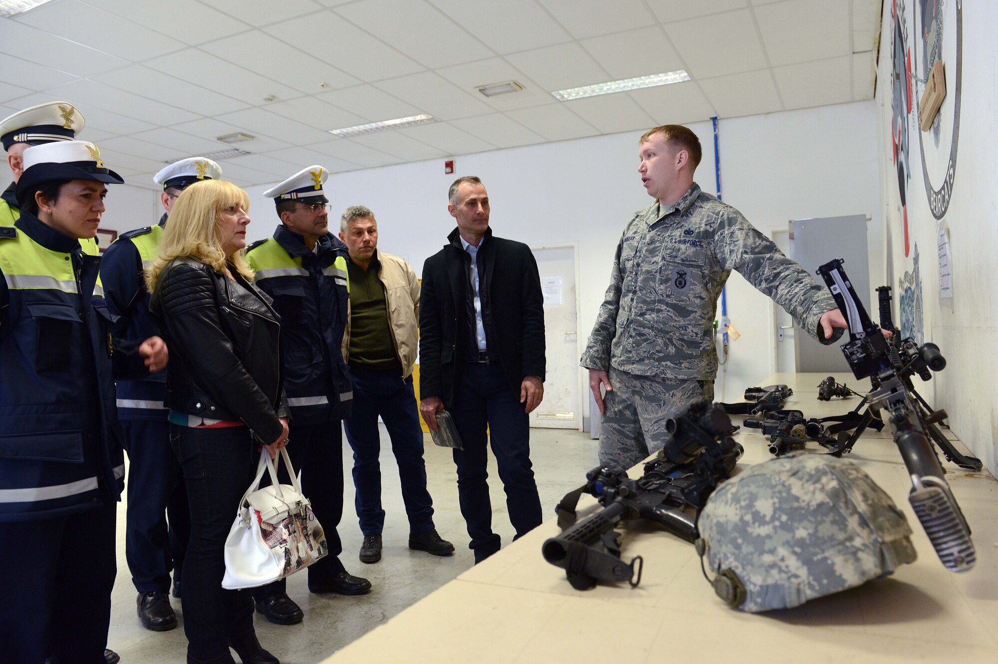 U.S. Air Force Staff Sgt. Jeffrey Sindelar, 31st Security Forces Squadron combat arms noncommissioned officer in charge, explains to local Italian police officials the type of weapons Aviano defenders carry, March 20, 2015, at Aviano Air Base, Italy. During a tour, Aviano Polizia members and the Venice Polizia K-9 unit visited the 31st SFS armory, indoor firing range and the military working dog section. (U.S. Air Force photo by Airman 1st Class Deana Heitzman/Released)