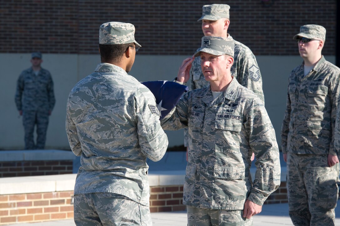 Col. Brad Hoagland, 11th Wing/Joint Base Andrews commander, salutes a U.S. Flag during a retreat ceremony in front of the Jones Building on JBA, Md., March 23, 2015. The ceremony was held to retire the flag after it was no longer deemed a fitting emblem for display. (U.S. Air Force photo/Airman1st Class Ryan J. Sonnier)