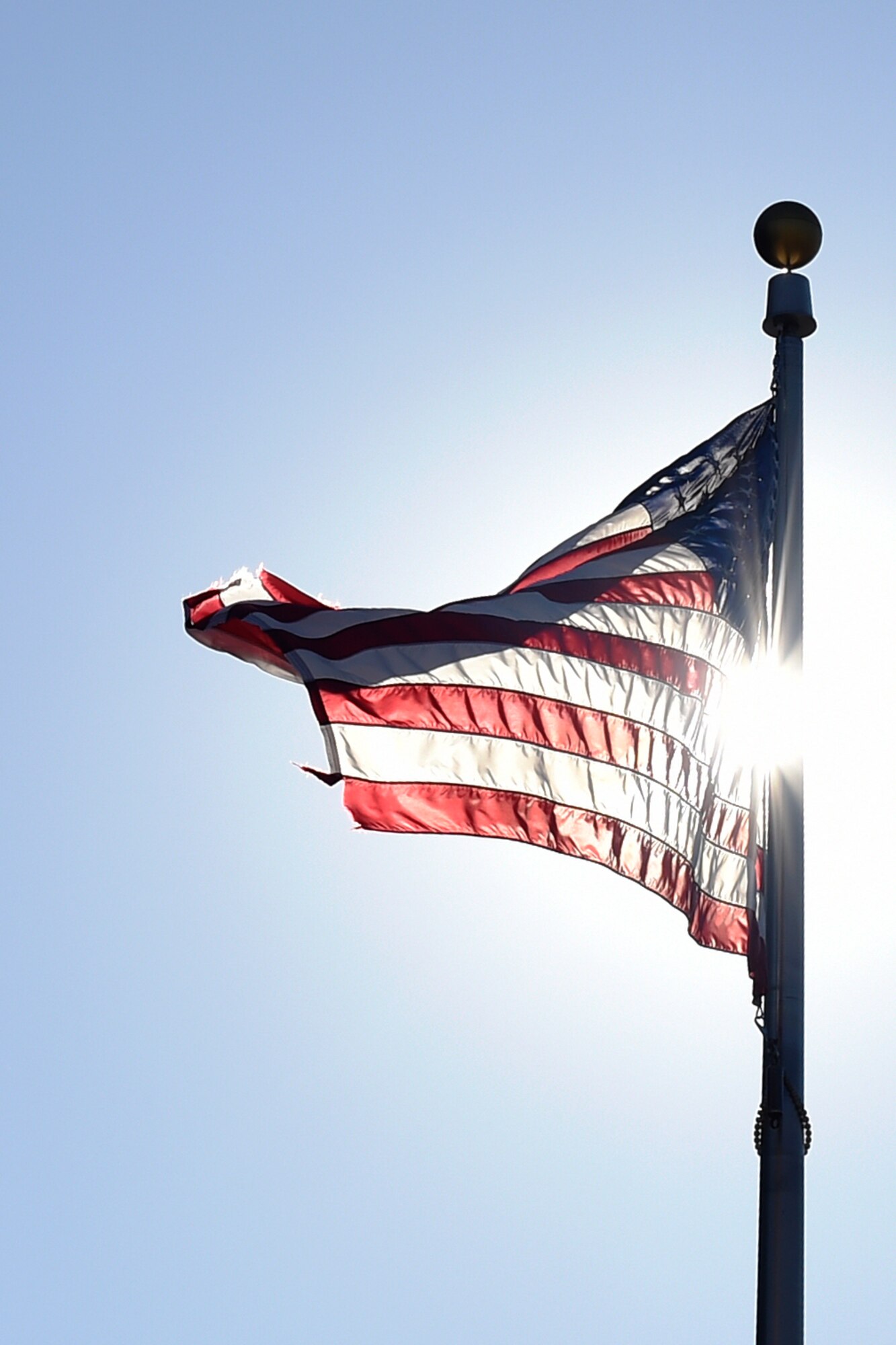 A U.S. Flag waves in the wind during its retirement ceremony in front of the Jones Building on Joint Base Andrews, Md., March 23, 2015. Once a flag is in a condition no longer deemed a fitting emblem for display, it is retired and destroyed in a dignified way. (U.S. Air Force photo/Airman 1st Class Ryan J. Sonnier)
