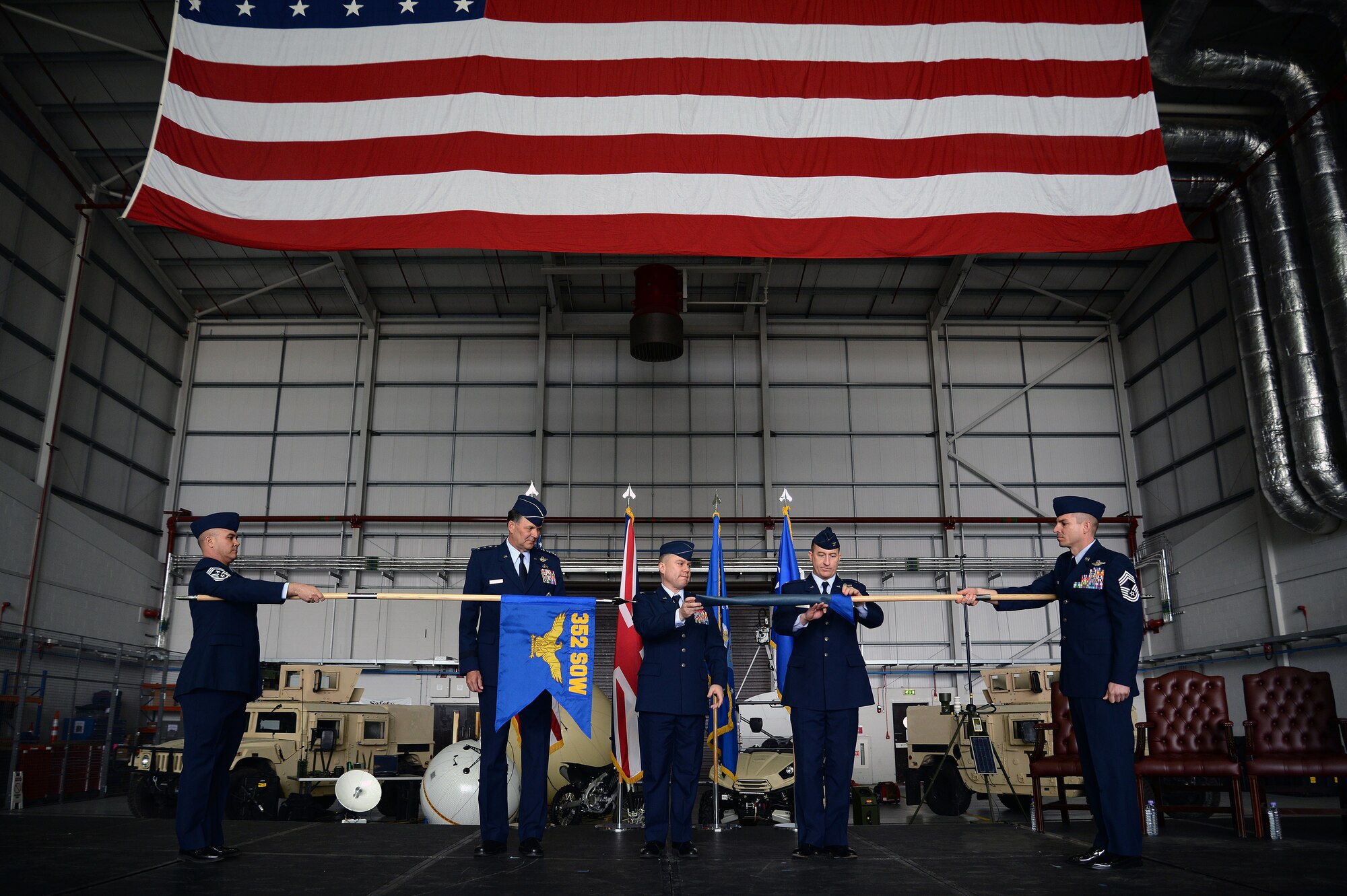 U.S. Air Force Lt. Gen. Brad A. Heithold, second from left, Air Force Special Operations Command commander, U.S. Air Force Col. William Holt, center, 352nd Special Operations Wing commander, and U.S. Air Force Lt. Col. Nathan Green, second from right, 752nd Special Operations Group commander, perform the 352nd SOW activation ceremony, March 23, 2015, on RAF Mildenhall, England. The 352nd SOW is responsible for planning and executing specialized and contingency operations using advanced aircraft, tactics and air refueling techniques to infiltrate, exfiltrate and resupply special operations forces. (U.S. Air Force photo by Senior Airman Christine Griffiths)
