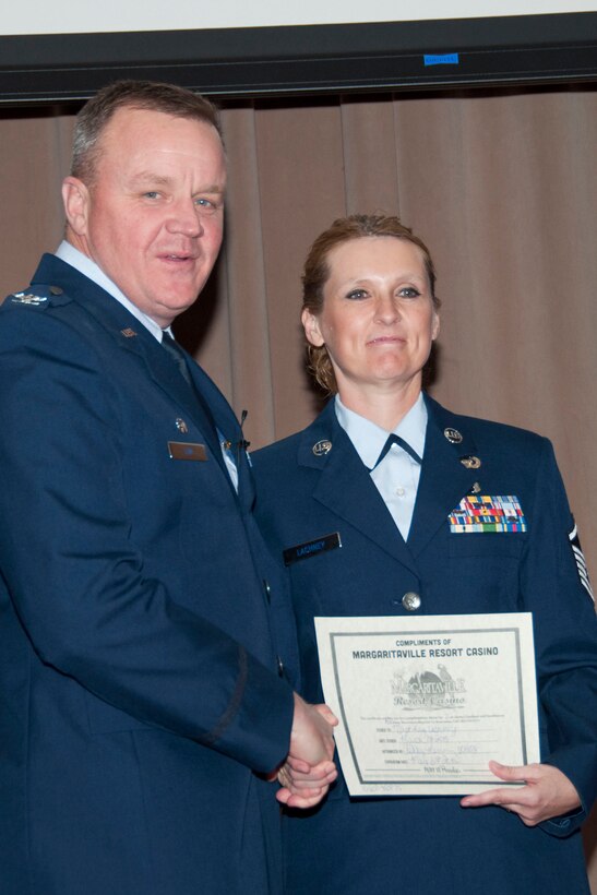 U.S. Air Force Col. Bruce Cox, 307th Bomb Wing commander, congratulates Master Sgt. Kay Lachney for being selected as the First Sergeant of the Year for 2014, March 8, 2015, Barksdale Air Force Base, La. Lachney is assigned to the 307th Security Forces Squadron. (U.S. Air Force photo by Tech. Sgt. Theodore Daigle/Released)