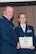 U.S. Air Force Col. Bruce Cox, 307th Bomb Wing commander, congratulates Master Sgt. Kay Lachney for being selected as the First Sergeant of the Year for 2014, March 8, 2015, Barksdale Air Force Base, La. Lachney is assigned to the 307th Security Forces Squadron. (U.S. Air Force photo by Tech. Sgt. Theodore Daigle/Released)