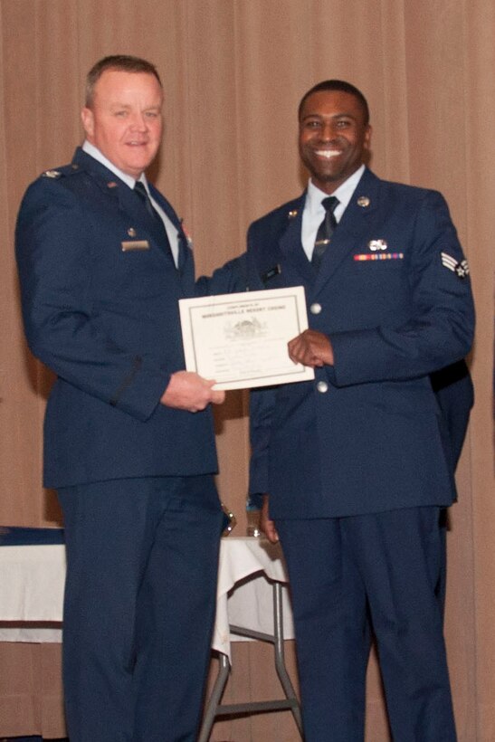 U.S. Air Force Col. Bruce Cox, 307th Bomb Wing commander, congratulates Airman 1st Class Joseph Moore for being selected as the Airmen of the Quarter for the third quarter of 2014 and Airman of the Year for 2014, March 8, 2015, Barksdale Air Force Base, La. Moore is assigned to the 307th Maintenance Squadron. (U.S. Air Force photo by Tech. Sgt. Theodore Daigle/Released)