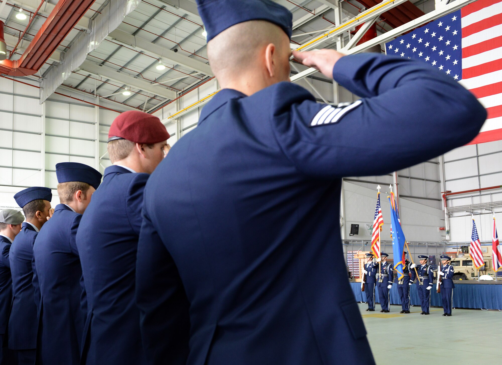 Air Commandos from the 752nd Special Operations Group render a salute as the U.S. and British national anthems are played just prior to the official redesignation of the 352nd Special Operations Group to the 352nd Special Operations Wing March 23, 2015, in Hangar 814 on RAF Mildenhall, England. Immediately following the anthems, the 352nd Special Operations Group was redesignated as the 352nd Special Operations Wing. The 752nd Special Operations Group and the 352nd Special Operations Maintenance Group were activated. (U.S Air Force photo by Tech. Sgt. Stacia Zachary/Released)
