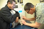 Private 1st Class Robin Cornelius, Pubic Health Command, Fort Hood, vaccinates Juan Gomez's dog, Cody, with the rabies vaccine March 9 at Joint Base San Antonio-Randolph.
(U.S. Air Force photo by Joel Martinez)
