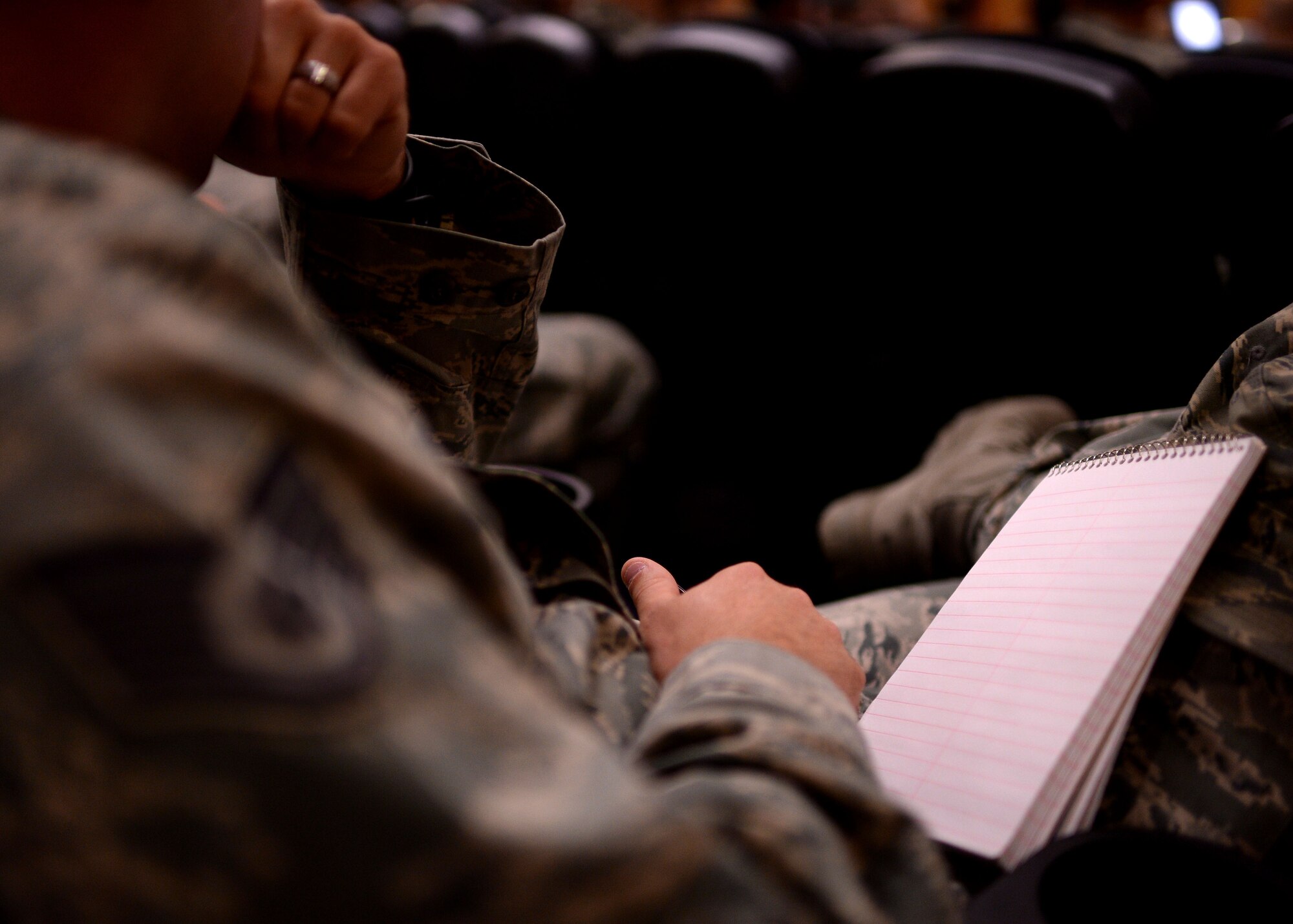 A U.S. Air Force Airman prepares to take notes during an enlisted briefing presented by U.S. Air Force Chief Master Sgt. Brian Gates, 52nd Fighter Wing command chief, March 25, 2015, in the theater at Spangdahlem Air Base, Germany. Gates hosted three separate mass briefings to share the latest enlisted information with as many Airmen as possible. (U.S. Air Force photo by Staff Sgt. Daryl Knee/Released)