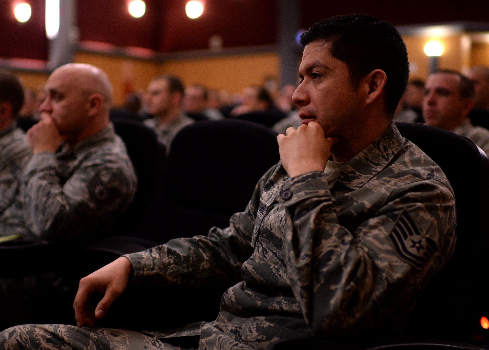U.S. Air Force Staff Sgt. Jose MataRamirez, 52nd Civil Engineer Squadron and audience member, listens to U.S. Air Force Chief Master Sgt. Brian Gates, 52nd Fighter Wing command chief, during an enlisted Airmen briefing March 24, 2015, in the theater at Spangdahlem Air Base, Germany. Gates delivered the latest news regarding enlisted professional military education, the enlisted evaluation system, and developmental special duties. (U.S. Air Force photo by Staff Sgt. Daryl Knee/Released)