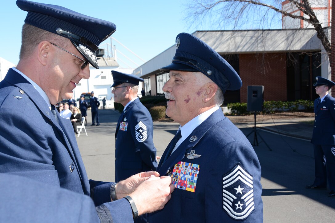 U.S. Air Force Brig. Gen. Roger E. Williams Jr. Assistant Adjutant General for Air, presents outgoing State Command Chief Master Sgt. Bruce G. Pickett, North Carolina Air National Guard, the Air Force Meritorious Service Medal during a Change of Authority ceremony held at the North Carolina Air National Guard base, Charlotte Douglas Int'l. Airport, Feb. 8, 2015. (U.S. Air National Guard photo by Master Sgt. Rich Kerner, 145th Public Affairs/Released)
