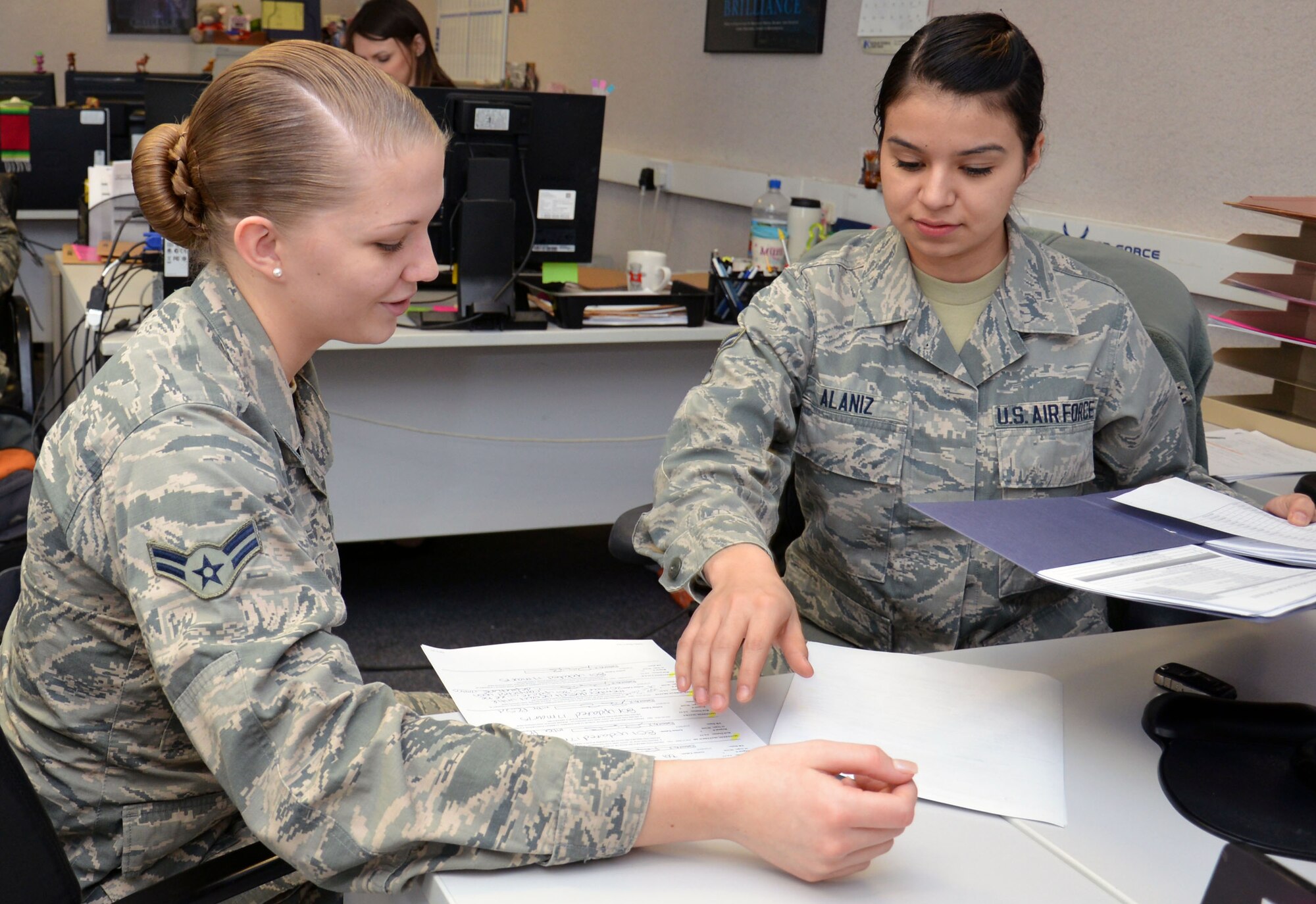 U.S. Air Force Airman 1st Class Desiree Alaniz, right, 100th Force Support Squadron Career Development technician from Pomona, Calif., trains U.S. Air Force Airman 1st Class Paige Becker, 100th Force Support customer support apprentice from Richlands, Calif., on personnel outbound processes and transaction register data processing, March 18, 2015, on RAF Mildenhall, England. Alaniz earned the Square D Spotlight for exhibiting the Air Force core value of Excellence in All We Do. (U.S. Air Force photo by Gina Randall/Released)