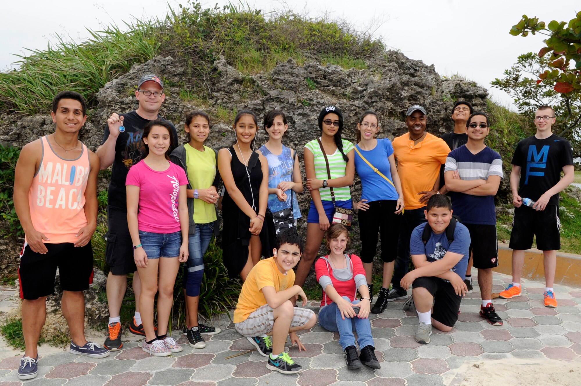 Catholic youth group members from Kadena Air Base, Japan, pose for a photo after finding a geocoin while geocaching near Araha Beach, Japan, March 21, 2015. Geocaching is a new century treasure hunt using GPS and clues provided on a website. Geocoins can occasionally be found in geocaches and are meant to be taken, placed in different caches and tracked around the world. (U.S. Air Force photo by Staff Sgt. Marcus Morris)
