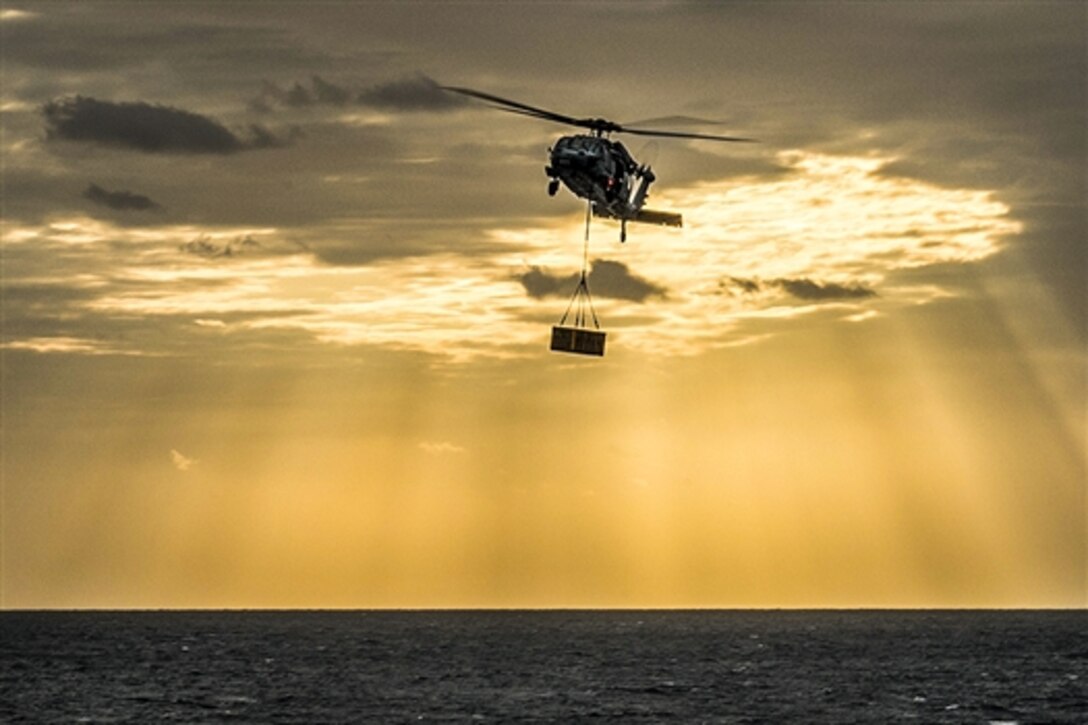 An MH-60S Seahawk helicopter delivers supplies to the amphibious assault ship USS Bonhomme Richard during a replenishment in the East China Sea, March 24, 2015. The helicopter is assigned to Helicopter Sea Combat Squadron 25.